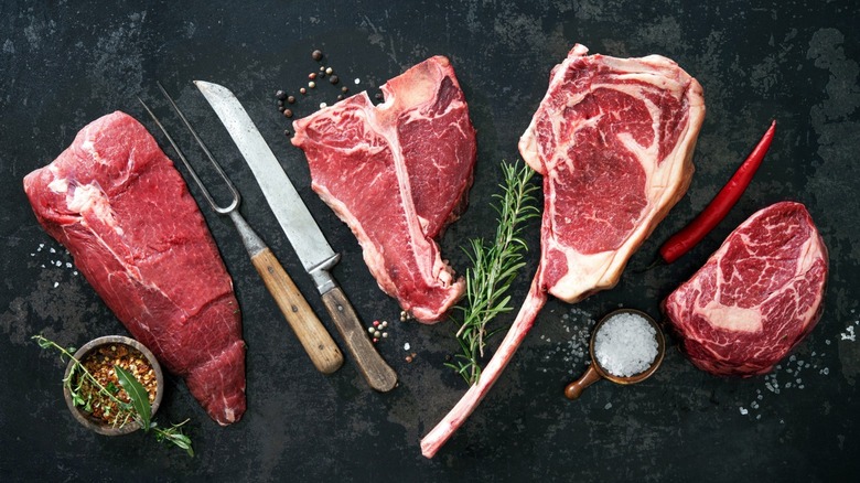 raw steak with pepper flakes on dark background