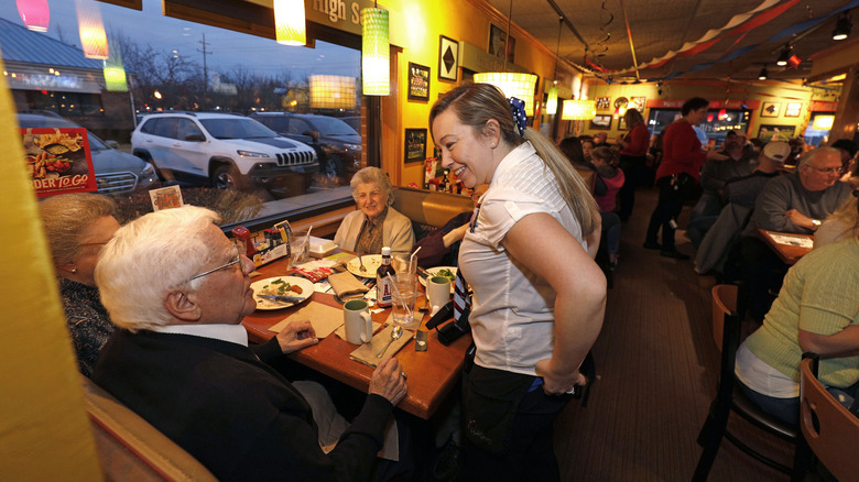 Applebee's server chatting with customers