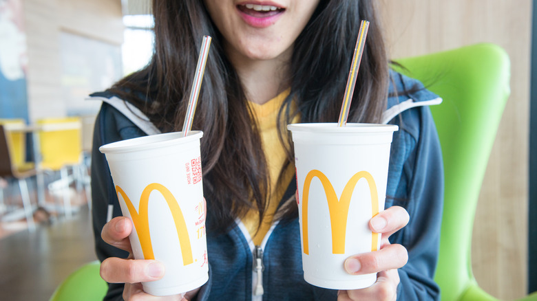 Woman holding two McDonald's drinks