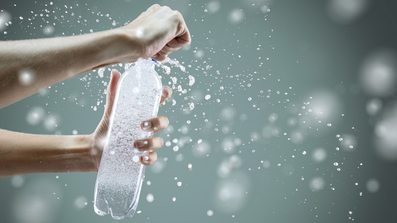 A person opening a bottle of sparkling water 