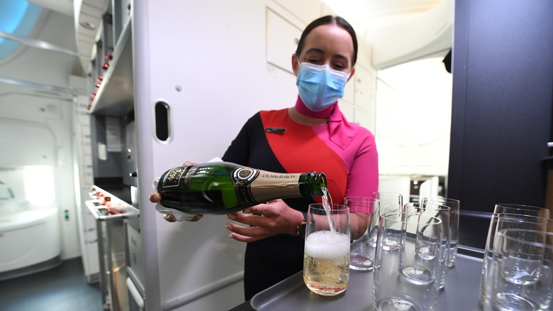 Flight attendant pouring alcohol in plane