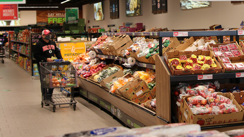 man pushing cart inside Aldi grocery store