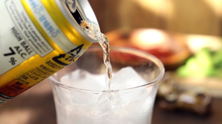 pouring canned cocktail into glass