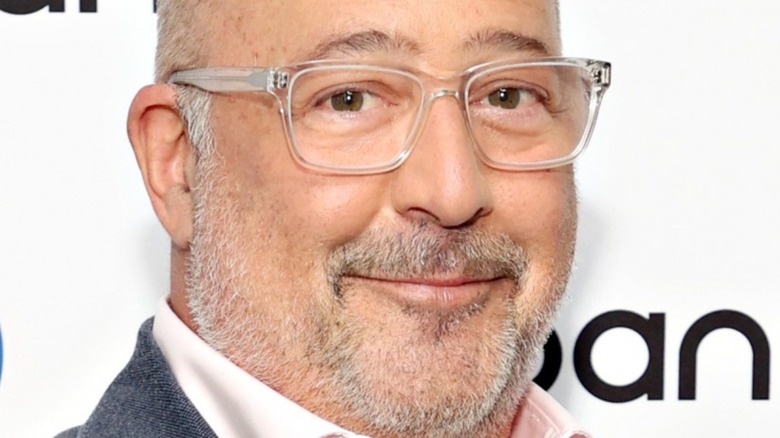 Close up of Andrew Zimmern wearing glasses with slight smile