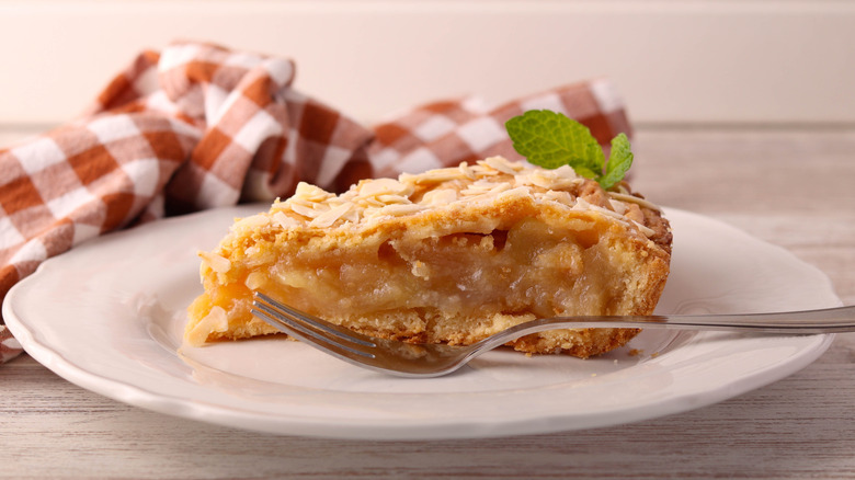 Slice of apple pie on a plate with a fork