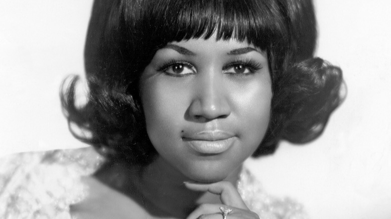 Young Aretha Franklin smiling in black and white
