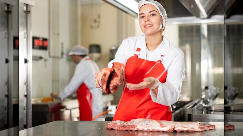 A butcher showing a cut of meat