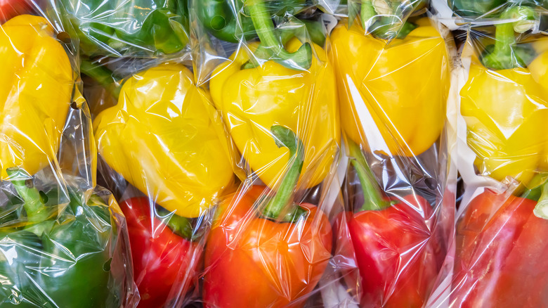 Red, yellow, and green bell peppers in clear plastic packaging