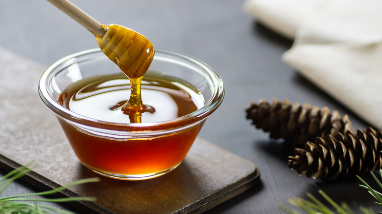 A honey pot and honeycombs against a white background