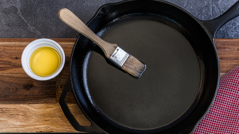 Brush with oil rests on a cast iron skillet