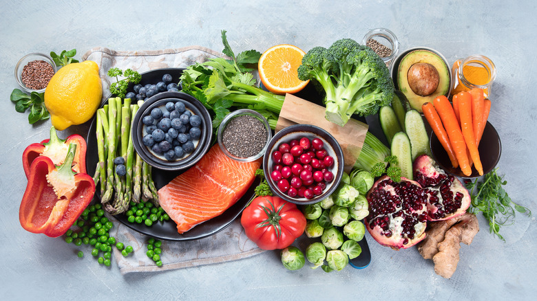 Healthy food selection on gray background. Detox and clean diet concept. Foods high in vitamins, minerals and antioxidants. Anti age foods. 