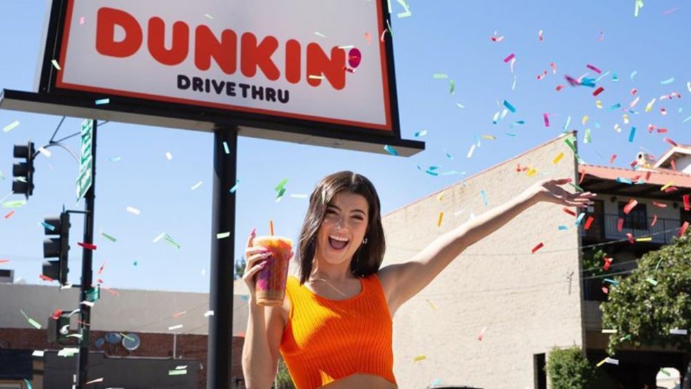 Charli D'Amelio standing outside Dunkin' with her signature drink