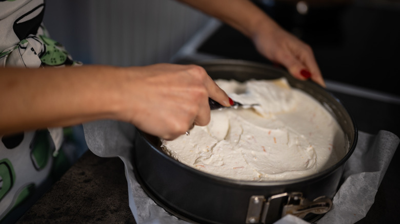 Spreading cheesecake mixture into pan