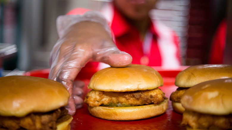 Person reaches to pick up fried Chick-fil-A sandwich