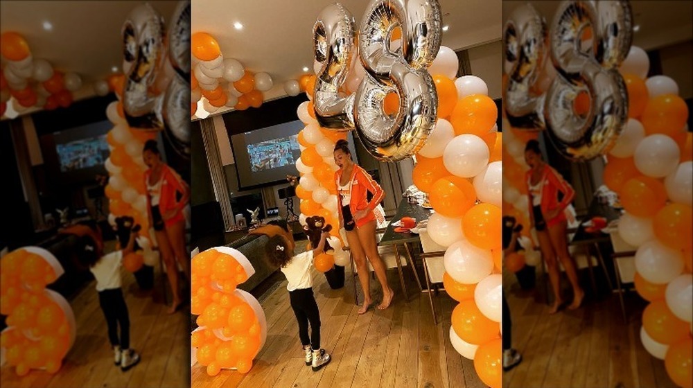 Chrissy Teigen with daughter Luna at Hooters-themed party