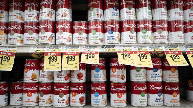 A variety of types of canned Campbell's condensed soups on a grocery store shelf