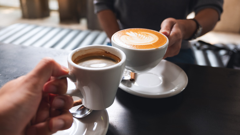 hands clinking coffee mugs