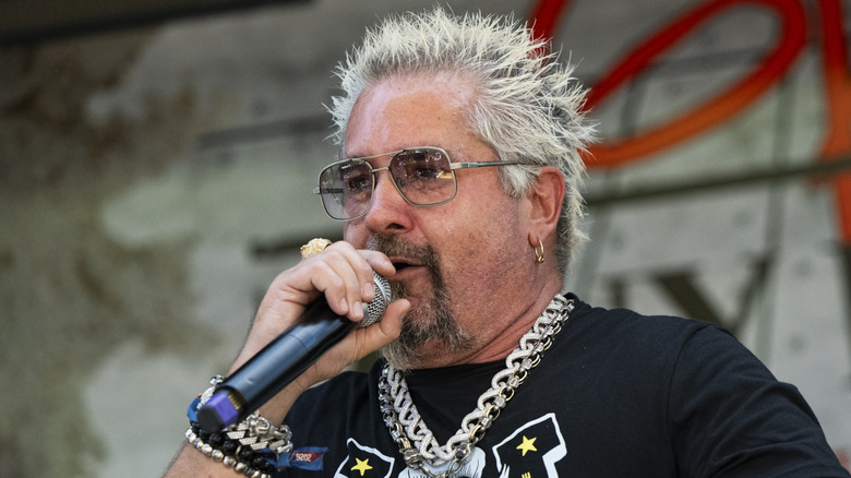 Guy Fieri speaking holding a microphone