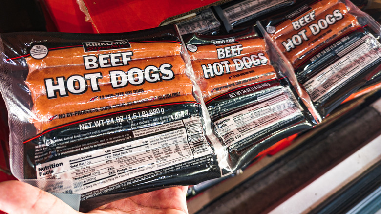 A stack of packages of Kirkland Signature beef hot dogs on sale at Costco