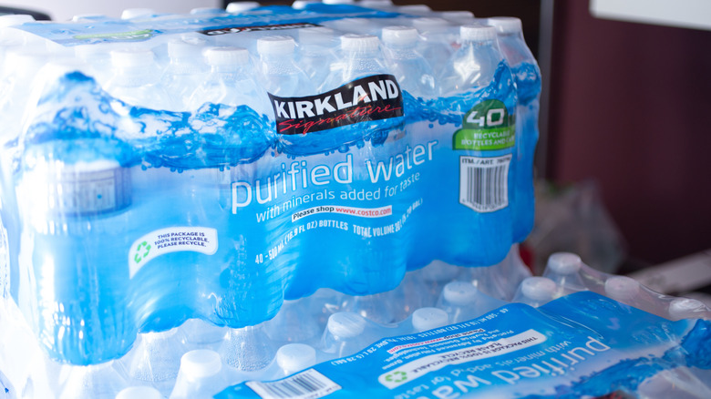 Packs of 40 Kirkland Signature water bottles sit on shelves.