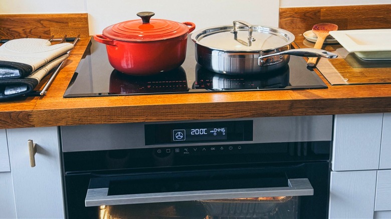 Several dishes being cooked on a modern induction range.