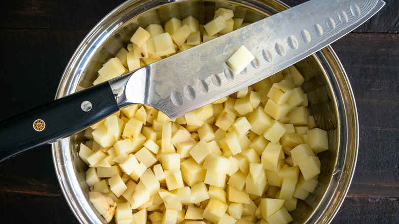 Santoku set on top of pot of diced potatoes