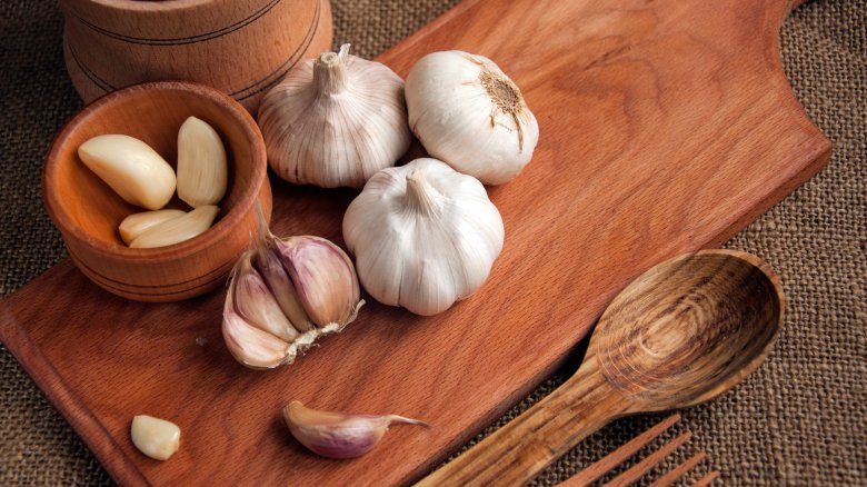 Whole and clove garlic on cutting board