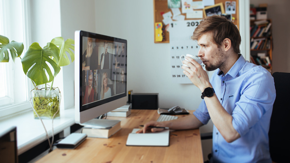 Man drinking coffee while working