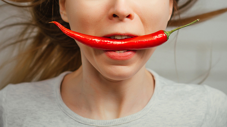 Hot pepper in woman's mouth