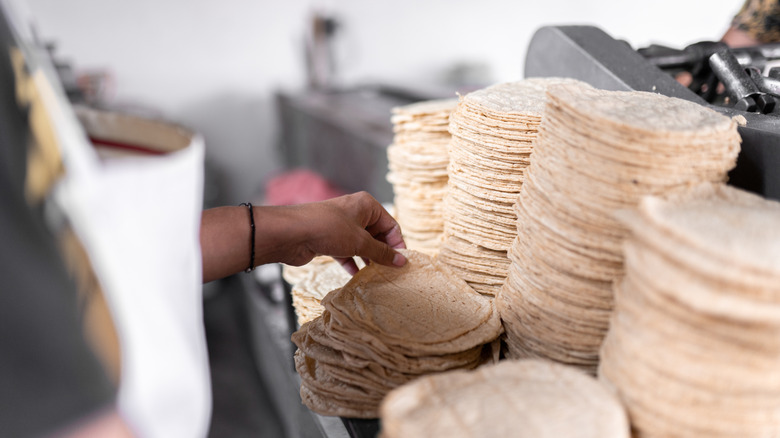 chef picking tortillas off stack
