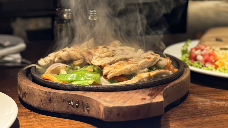 A steaming skillet of chicken fajitas