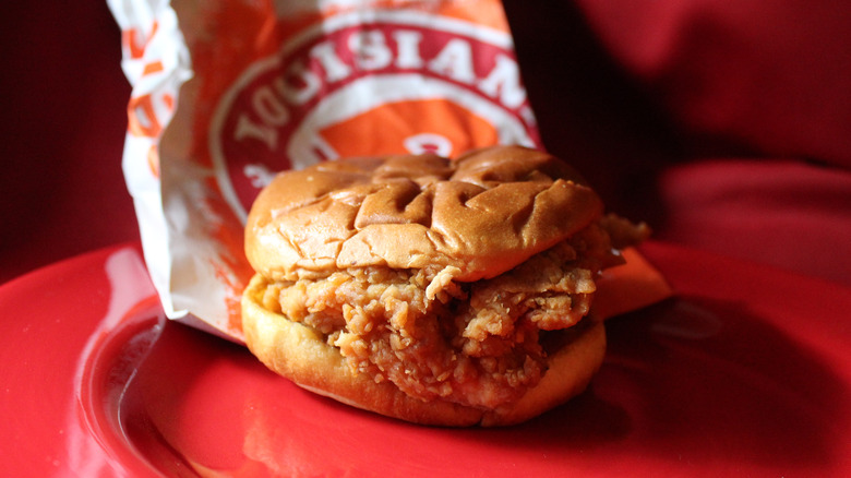 Popeyes chicken sandwich on red plate