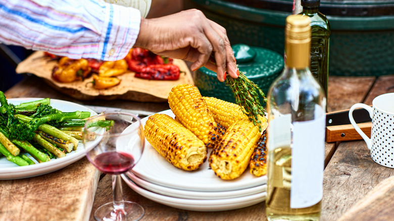 vegetable side dishes on a table with wine glasses