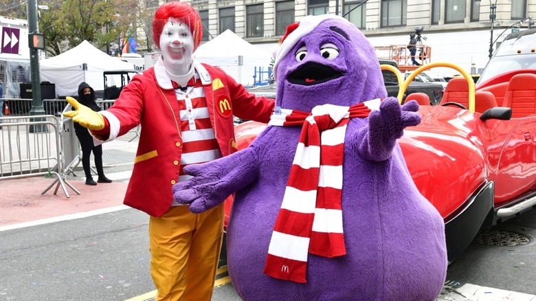 Grimace and Ronald mcdonald walking in parade