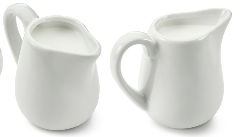 Two white creamer jars full of dairy