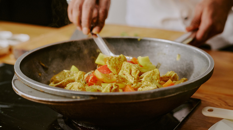 Cooking vegetables in a wok on an induction stovetop