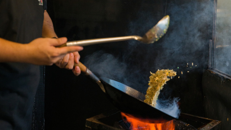 Using a wok over a flame