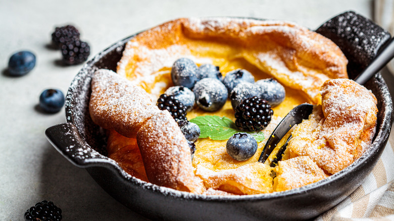 Dutch baby covered in powdered sugar and berries