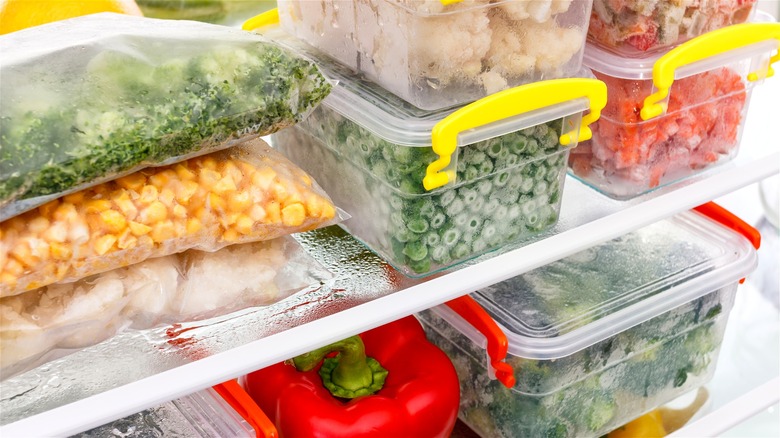 Containers of frozen food on refrigerator shelves.
