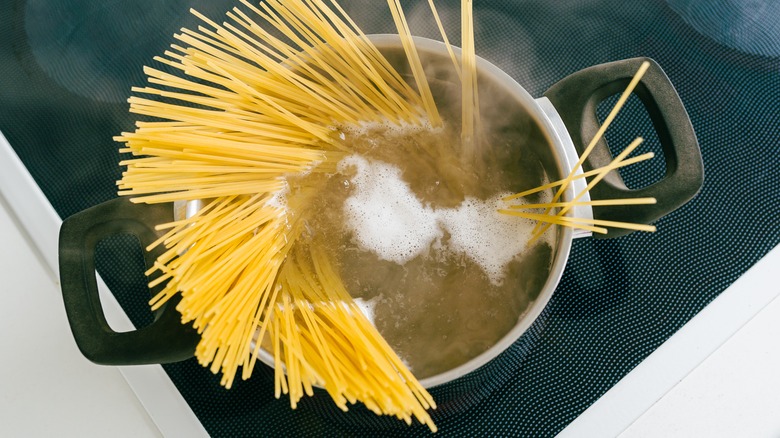 dried pasta sticking out of boiling water