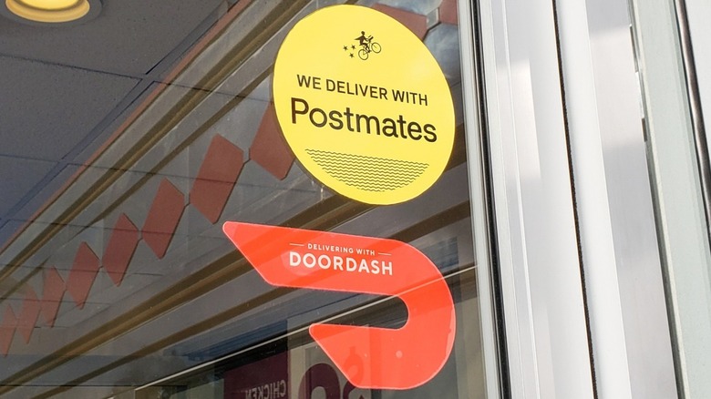 Postmates and DoorDash sign at a restaurant