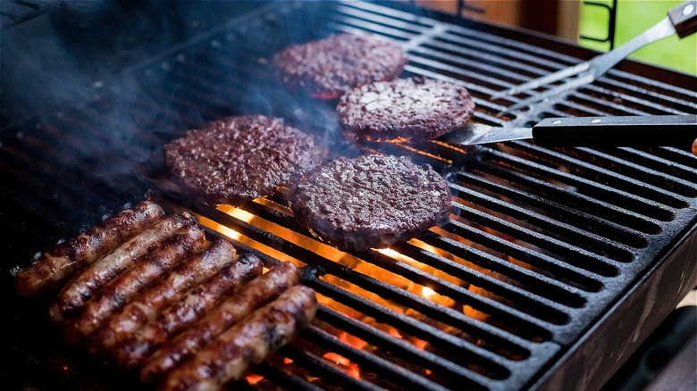 Closeup of grill with burgers and hot dogs