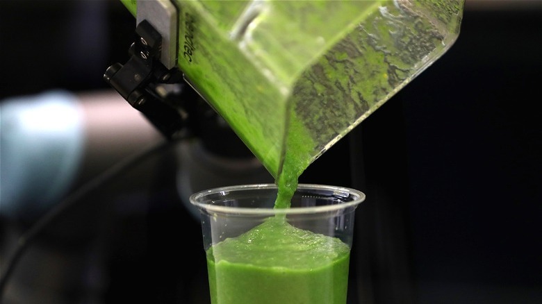 Robotic arm pouring green smoothie