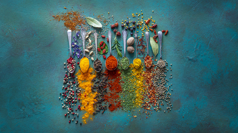 Spoons spilling variety of herbs and spices