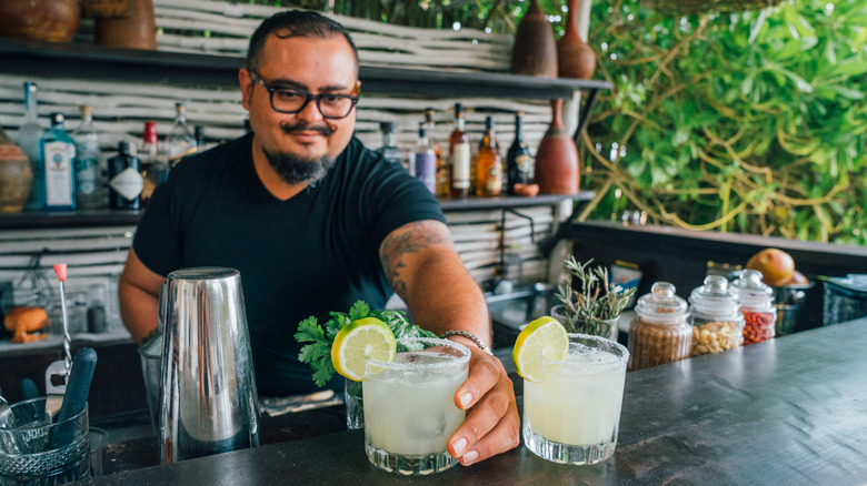 bartender placing margaritas on the bar