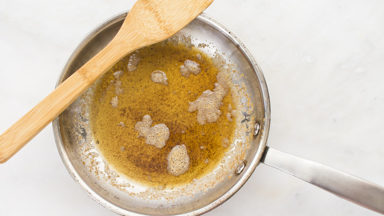 brown butter in a pan with a wooden spatula