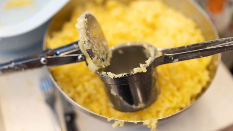 a ricer with a pan of mashed potatoes