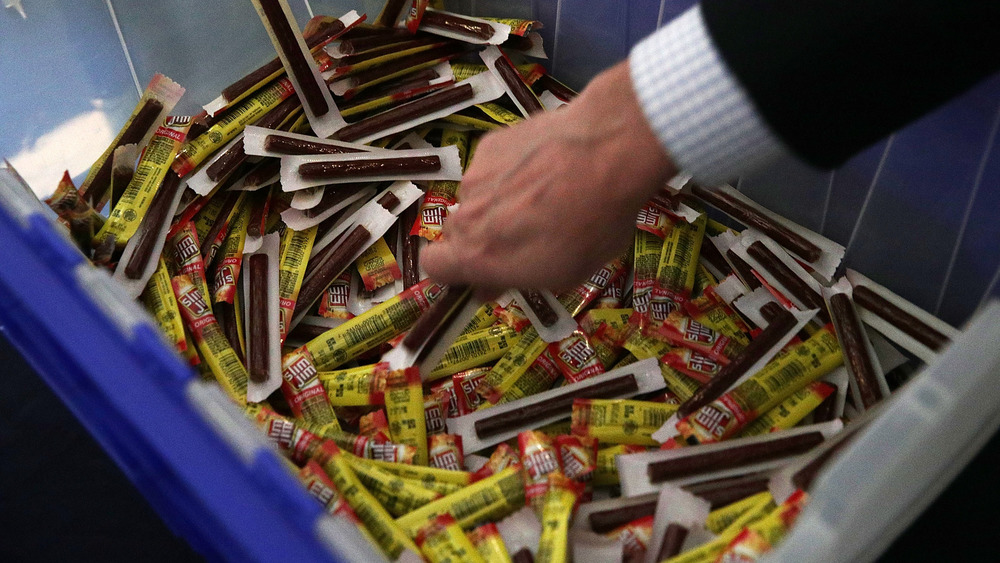 Hand reaching into crate of Slim Jims