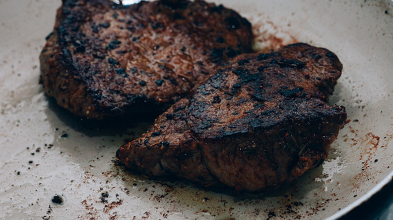 Two charred beef steaks on a plate