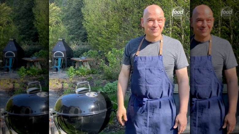 micheal symon in front of a charcoal grill